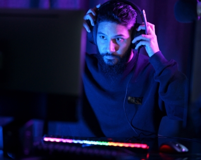 Man sitting at computer puts on gaming headset